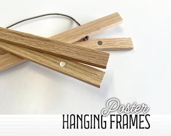 May include: Three wooden poster hanging frames with magnetic closures. The frames are made of natural wood and are designed to hang posters without the need for glass or other materials.