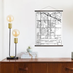 Puede incluir: Impresión de mapa en blanco y negro de Broken Arrow, Oklahoma, colgada en una pared blanca con un marco de madera. El mapa se muestra sobre un fondo blanco con líneas y texto negros.