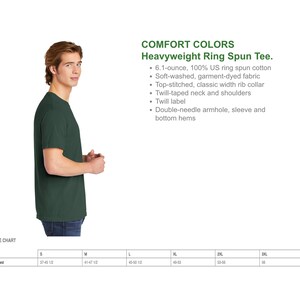 May include: A green t-shirt with the text "COMFORT COLORS Heavyweight Ring Spun Tee." The text lists the following features: 6.1-ounce, 100% US ring spun cotton, soft-washed, garment-dyed fabric, top-stitched, classic width rib collar, twill-taped neck and shoulders, twill label, double-needle armhole, sleeve and bottom hems. A size chart is included with measurements in inches.
