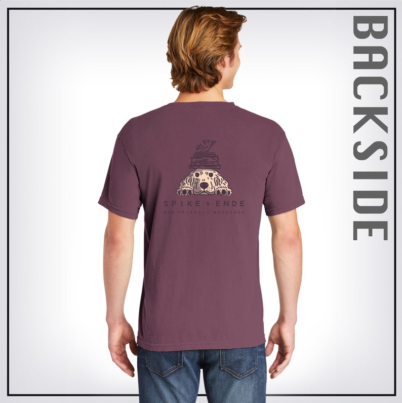 May include: A maroon t-shirt with a graphic of a dog peeking out from behind a stack of books. The text "SPIKE & ENDE DOG-FRIENDLY BOOKSHOP" is printed below the graphic.