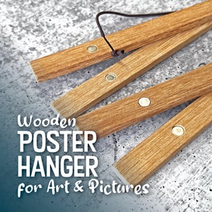May include: Wooden poster hanger with four brown wooden bars and metal clips. The hanger is folded up and the text "Wooden POSTER HANGER for Art & Pictures" is visible in the foreground.