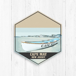 May include: A vintage-style illustration of a white lifeboat with the text "CAPE MAY" on the side, set against a beach scene with a cityscape in the background. The text "CAPE MAY NEW JERSEY" is displayed below the boat.