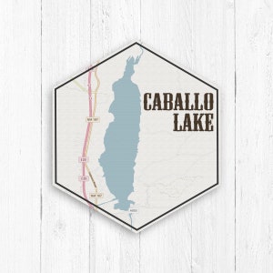 May include: A hexagonal sign with a map of Caballo Lake, New Mexico. The sign is brown with white text and a blue lake. The text on the sign reads "Caballo Lake".