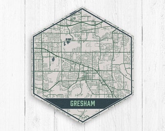Può includere: Una mappa esagonale di Gresham, Oregon, con sfondo bianco e linee verdi che rappresentano le strade. Il nome della città è stampato su uno stendardo blu scuro in basso.