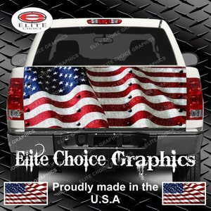 May include: A white pickup truck with a distressed American flag graphic on the tailgate. The graphic features a waving flag with red, white, and blue stripes and stars. The text "Elite Choice Graphics" is printed below the graphic, along with the phrase "Proudly made in the U.S.A."