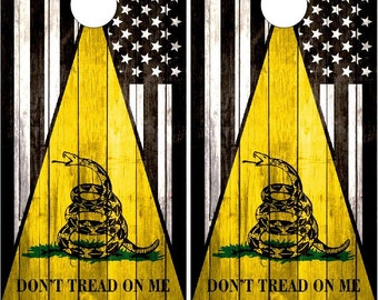 May include: Two wooden cornhole boards with a distressed American flag design. Each board features a yellow triangle with a black snake and the words "Don't Tread On Me".