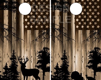 May include: A pair of wooden cornhole boards with a rustic wood grain design. The boards are decorated with a silhouette of a deer, trees, and a turkey. The boards also feature an American flag design.