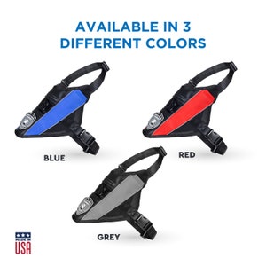 May include: A black dog harness with a reflective strip available in blue, red, and grey. The harness has a buckle closure and a handle on the top. The text "AVAILABLE IN 3 DIFFERENT COLORS" is at the top of the image. The text "BLUE", "RED", and "GREY" are below each harness. The text "MADE IN USA" is at the bottom of the image.