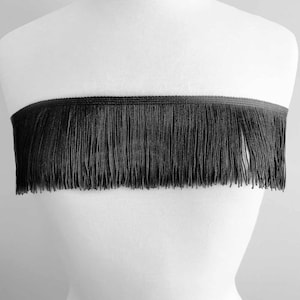 May include: Black fringe trim with a smooth, even texture. The fringe is approximately 1 inch long.