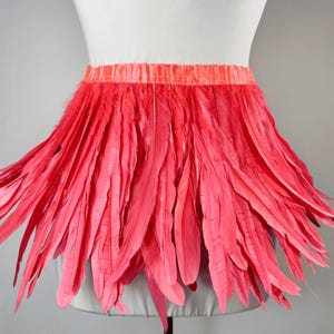May include: A bright pink feather trim with a satin ribbon waistband. This feather trim is perfect for adding a touch of glamour to any outfit.