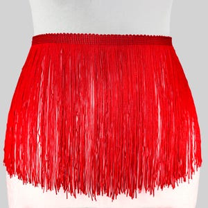 May include: Red fringe trim with a scalloped edge. The fringe is about 3 inches long.
