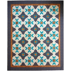 Könnte beinhalten: Eine Steppdecke mit einem geometrischen Muster aus türkisfarbenen, braunen und weißen Sternen auf cremefarbenem Hintergrund. Die Steppdecke ist von einem braunen und schwarzen Rand umgeben.