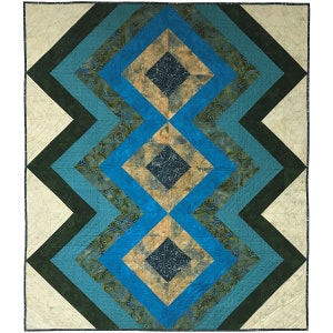 May include: A quilt featuring a geometric design of blue, green and beige squares. The squares are arranged in a repeating pattern of overlapping diamonds.