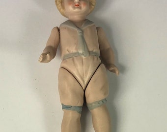 German All Bisque Doll Jointed Arms/Legs Embossed Pink Suit With Blue Collar & Tie.