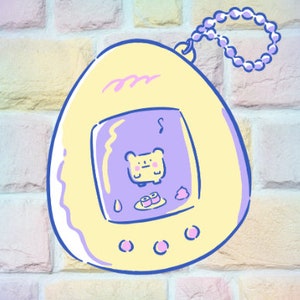 May include: A yellow and purple digital pet toy with a cartoon bear on the screen. The toy has a chain attached to it.