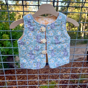 Chaleco infantil acolchado Daisy – Capa exterior de franela, relleno de algodón y bambú, cierre de botones, transpirable, cálido y elegante.