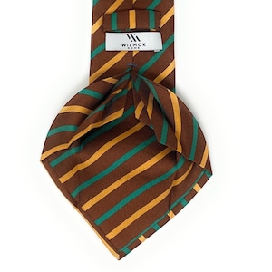 Op de afbeelding: Een gestreepte zijden stropdas in bruin en groen met een label met de tekst "WILMOK ROME".