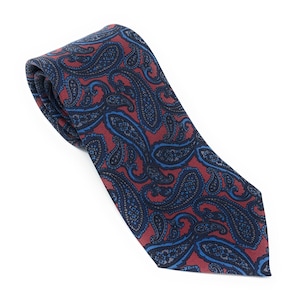 May include: A red and blue paisley patterned tie. The tie is made of a silky material and has a pointed tip.