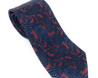May include: A red and blue paisley patterned tie. The tie is made of a silky material and has a pointed tip.