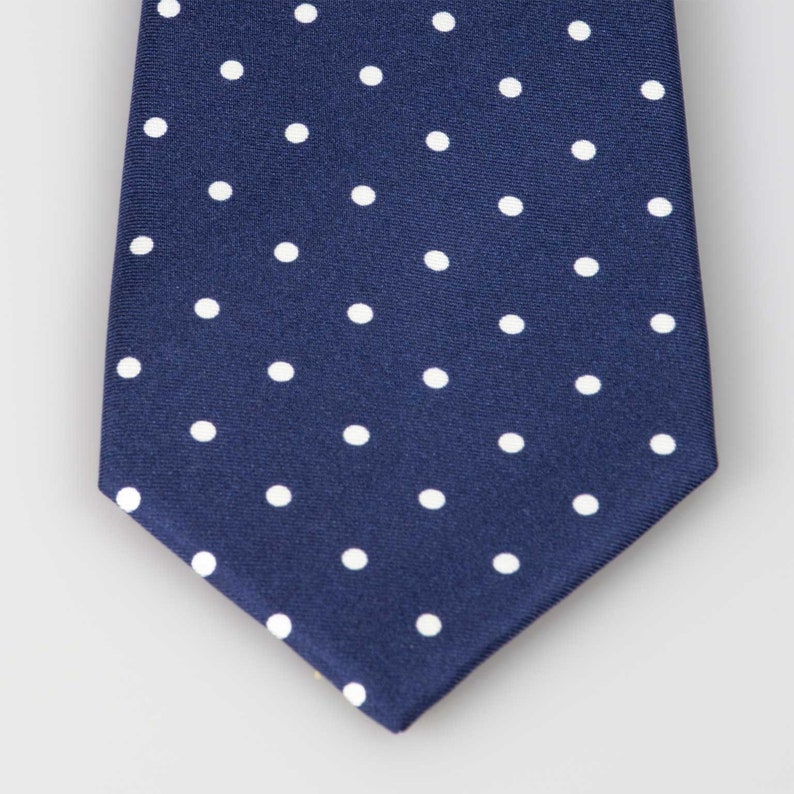 May include: A navy blue tie with a white polka dot pattern.