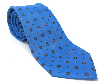May include: A blue silk tie with a repeating pattern of small red and black squares.