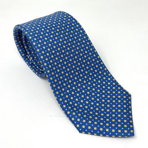 May include: A blue silk tie with a yellow and white geometric pattern.