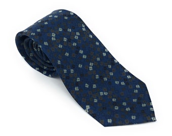 May include: A dark blue necktie with a pattern of small, light blue and gray flowers.