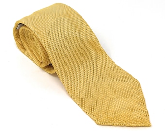 May include: A yellow silk tie with a textured pattern.