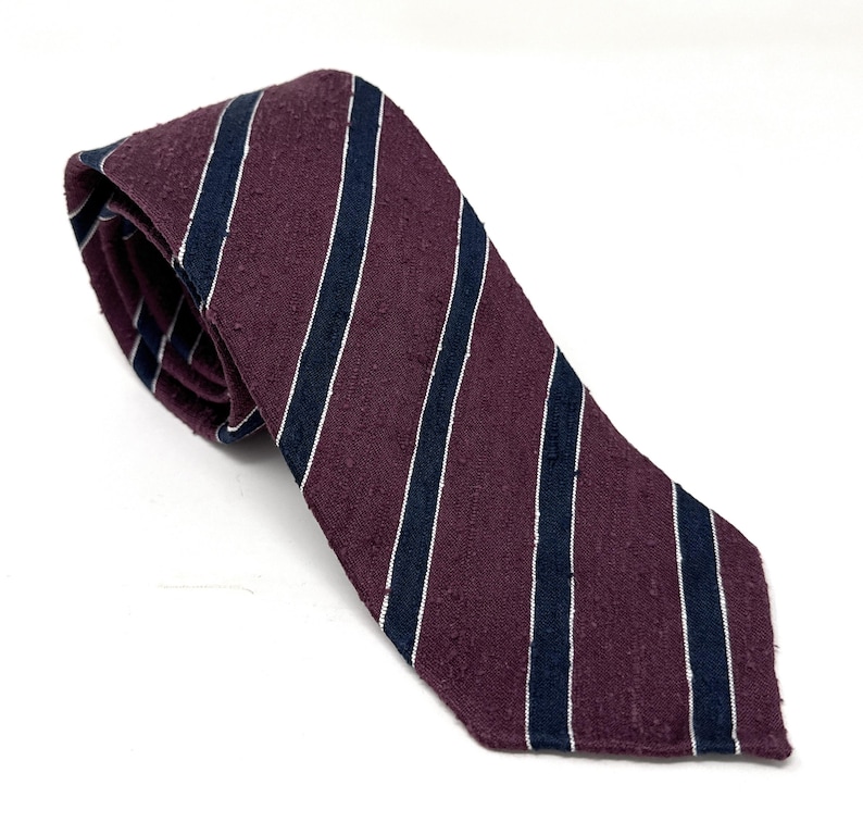 May include: A burgundy and navy blue striped tie with a textured surface.