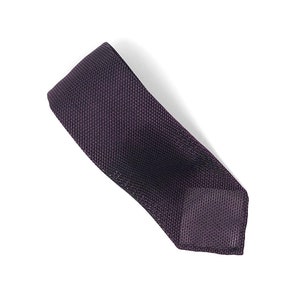 Puede incluir: Una corbata de punto de color morado oscuro con un patr&oacute;n de textura fina.