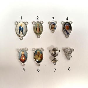 Puede incluir: Ocho abalorios de metal plateados con im&aacute;genes religiosas. Los abalorios presentan im&aacute;genes de la Virgen Mar&iacute;a, Jes&uacute;s, un c&aacute;liz y una monja. Los abalorios est&aacute;n numerados del 1 al 8.