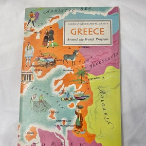 May include: A vintage educational booklet titled American Geographical Society Greece Around the World Program. The cover features a colorful illustrated map of Greece with labels for cities, regions, and seas, alongside drawings of people, a goat, and landmarks.