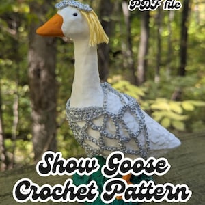 May include: A white goose figurine with an orange beak and yellow hair, adorned with a silver crocheted collar and headpiece. The base is green. Text on the image reads "digital download PDF file" and "Show Goose Crochet Pattern".