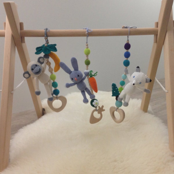 Wooden baby gym with 3 crochet toys: a white monkey, an arctic fox, a grey rabbit