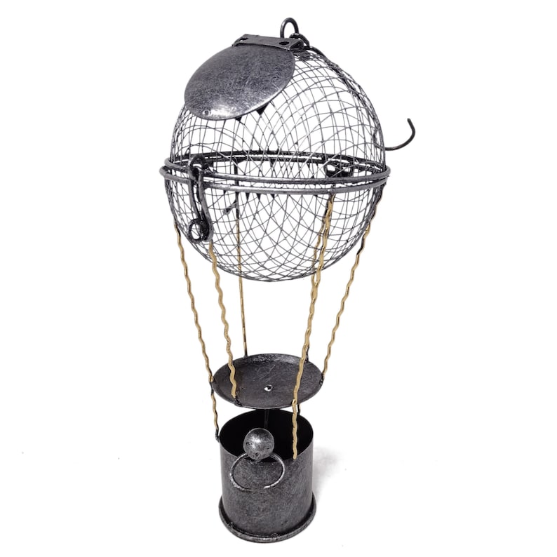 May include: A silver metal hot air balloon shaped decorative object with a wire mesh basket and gold colored strings. The balloon has a removable lid.
