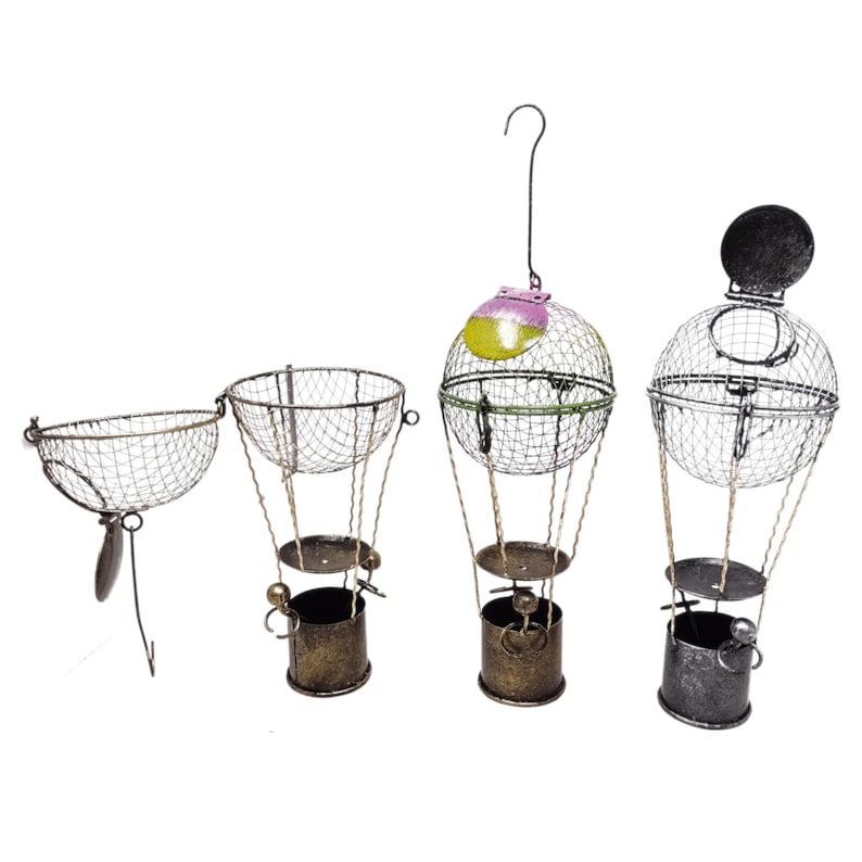 May include: Four decorative metal hot air balloon ornaments with wire baskets. The balloons are in various colors, including green, yellow, pink, and black. The baskets are made of wire and have a rustic look.