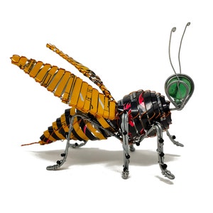 Escultura de abeja hecha con lata reciclada