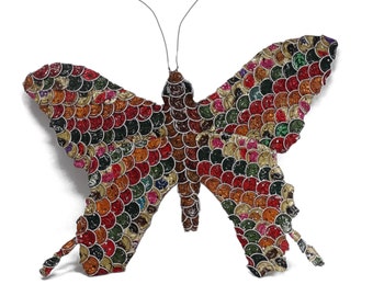 May include: A colorful butterfly made from bottle caps. The butterfly is made of a variety of colors, including red, orange, yellow, green, blue, and purple.