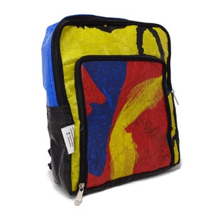 Pu&ograve; includere: Uno zaino colorato realizzato con materiali riciclati. Lo zaino ha un design astratto blu, giallo e rosso. Lo zaino ha una cerniera nera e una cinghia nera.