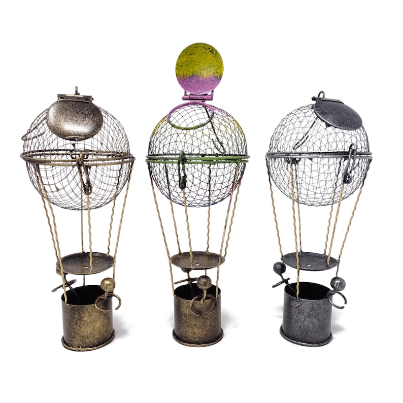 May include: Three decorative metal hot air balloons with wire mesh baskets and a gold, green, and gray color scheme.