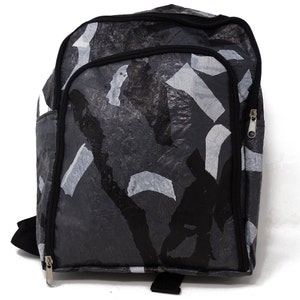 Pu&ograve; includere: Uno zaino nero e grigio con un motivo mimetico realizzato in plastica riciclata. Lo zaino ha due scomparti con cerniera e spallacci regolabili.