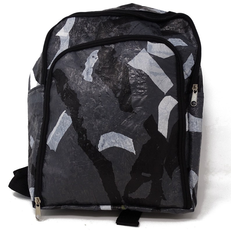 Pu&ograve; includere: Uno zaino nero e grigio con un motivo mimetico realizzato in plastica riciclata. Lo zaino ha due scomparti con cerniera e spallacci regolabili.