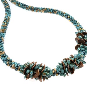May include: A teal and gold beaded necklace with three copper flower-shaped accents.
