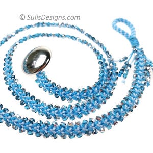 May include: A handcrafted blue and white beaded necklace with a silver clasp. The necklace is made of small, sparkling beads and has a braided design. The necklace is approximately 76 cm long.