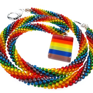 May include: A multi-strand rainbow beaded necklace with a rainbow glass pendant. The necklace is made with small, colourful beads and has a silver clasp. ©Sulis Designs