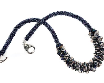 May include: A dark blue beaded necklace with a silver clasp and a cluster of iridescent beads in the center.