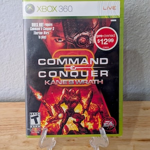 May include: Xbox 360 video game case for "Command & Conquer 3: Kane's Wrath." The cover features a red and black design with a futuristic soldier and the game's title. The case is pre-owned and includes the ESRB Teen rating.