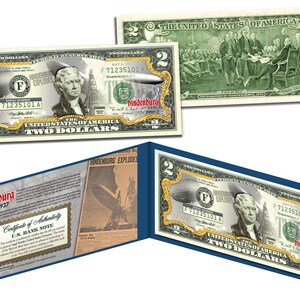 May include: A two dollar bill with a gold foil overlay featuring the Hindenburg airship. The bill is a replica of a US bank note with the text "Hindenburg Explodes" and "May 6, 1937" printed on it.