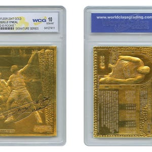 May include: A gold 1998 Fleer 23KT Shaqille O'Neal rookie card, graded WCG 10, in a protective case. The card features an embossed image of O'Neal playing basketball and his signature. The back of the card also has an embossed image of O'Neal.