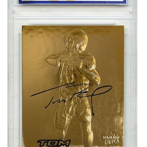 Puede incluir: Una tarjeta de novato de Tom Brady dorada de 2000 Fleer Ultra, calificada WCG 10. La tarjeta presenta un dise&ntilde;o de serie de firma azul met&aacute;lico y el texto "TOM BRADY" y "NEW ENGLAND PATRIOTS".